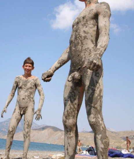 Nude boy covered in mud